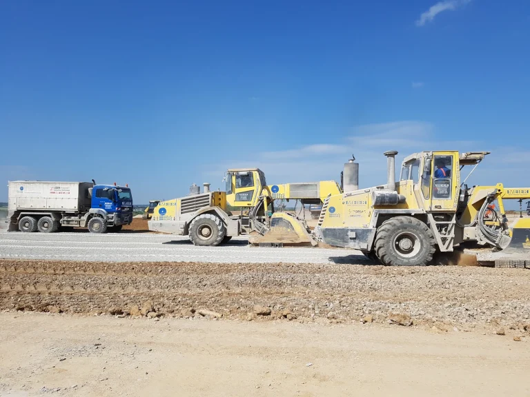 Mehrere Fahrzeuge zur Bodenstabilisierung auf einer Straße